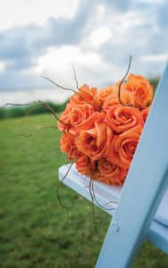 orange flower bouquet on blue chair